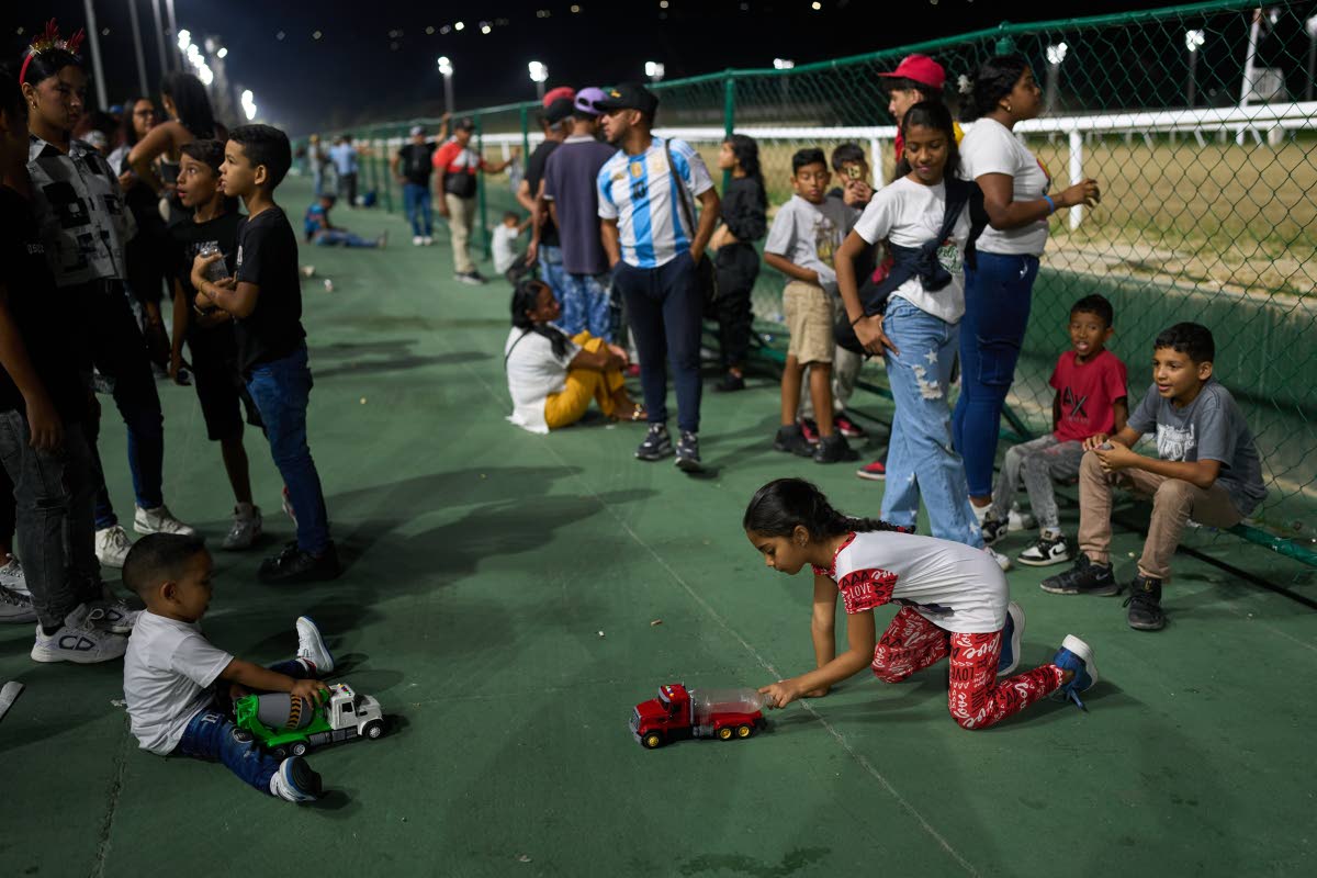 Children play during the 56th Jockey Challenge at the Rinconada racetrack in Caracas, Venezuela, Sunday, Dec. 14, 2025. 