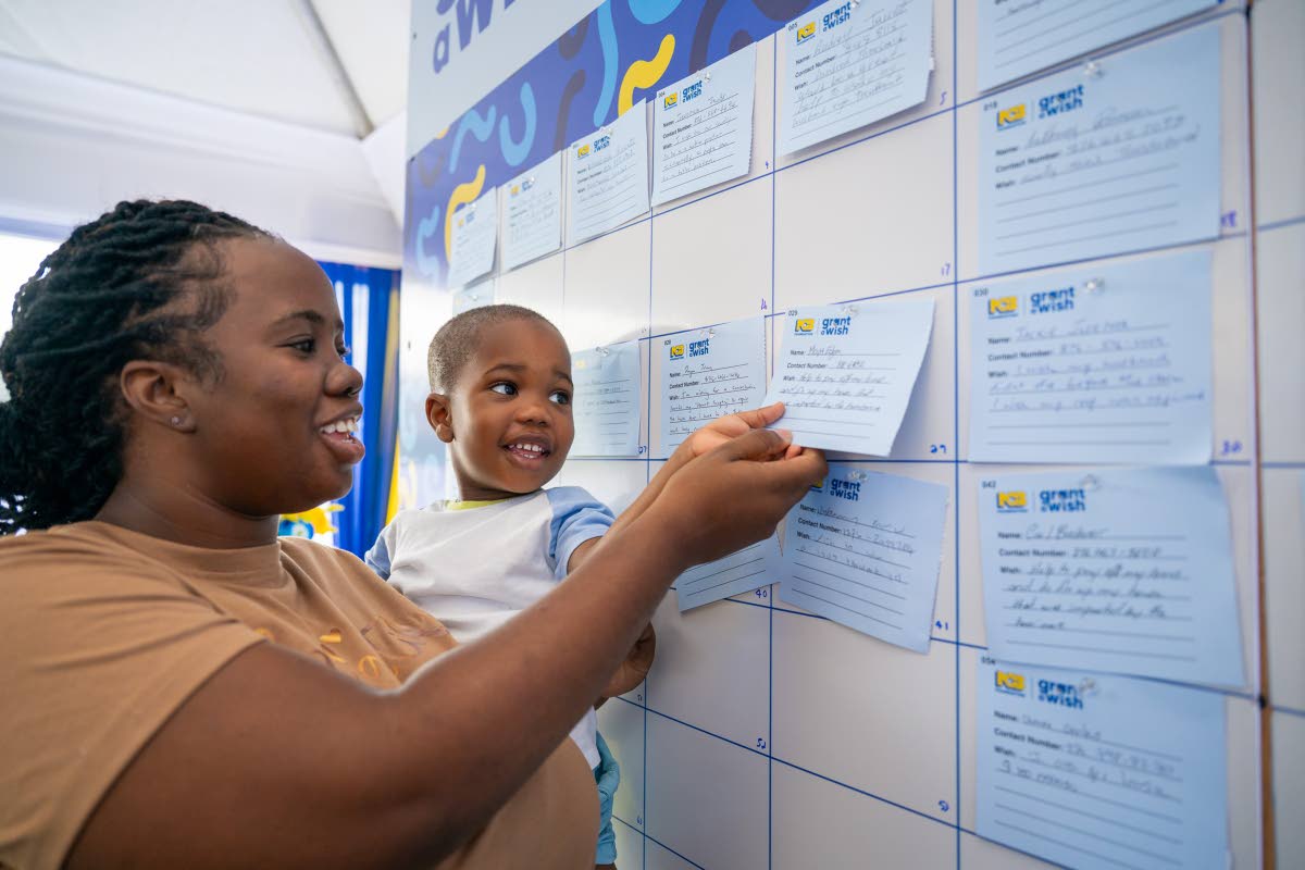 A mother and son share smiles as they review their wish on the Wishing Wall during the NCB Foundation’s Grant a Wish launch, held recently at NCB’s Fairview Financial Centre in Montego Bay, St James. 