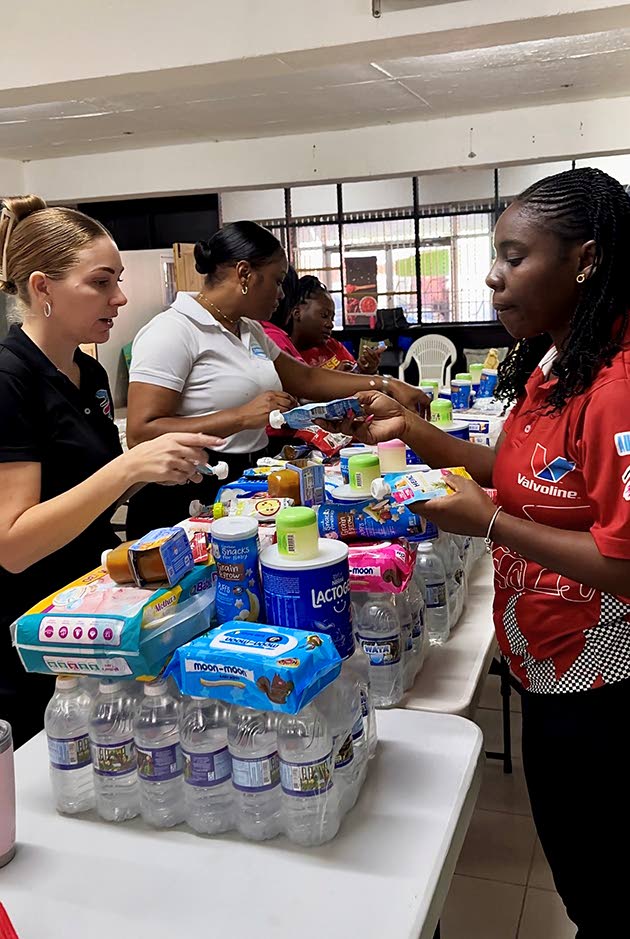 Members of the Stewart’s Automotive Group team pack food, water, and baby essentials into care bundles as the company ramps up relief efforts for families hardest hit by Hurricane Melissa in western Jamaica. 