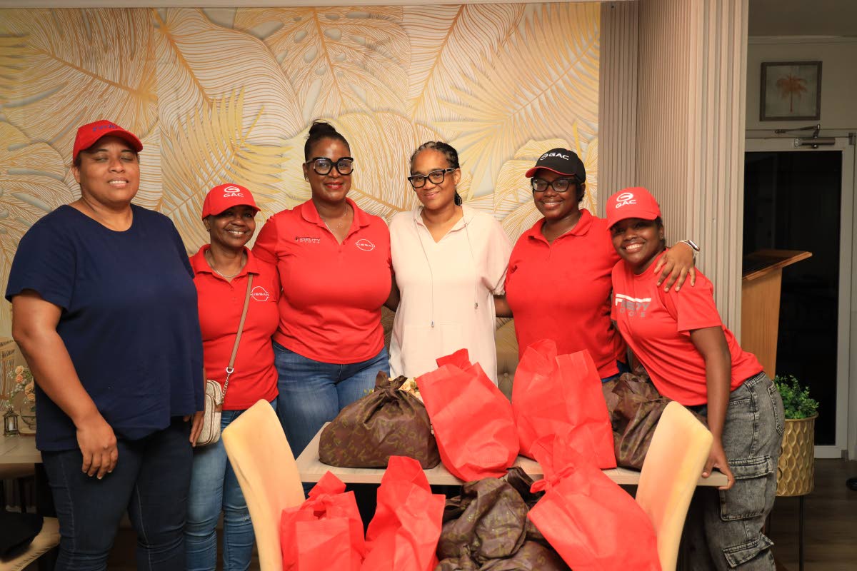 (left to right)Dr. Wendy Freckleton, Chairwoman of Candle in the Dark Ministry and The Fidelity Motors team (Ms. Andrea Davis, Mrs. Deborah Stewart, Ms. Anna-Kaye Wright, Mrs. Daina Lewis), hands over feminine hygiene relief packages to the ladies of Bisho