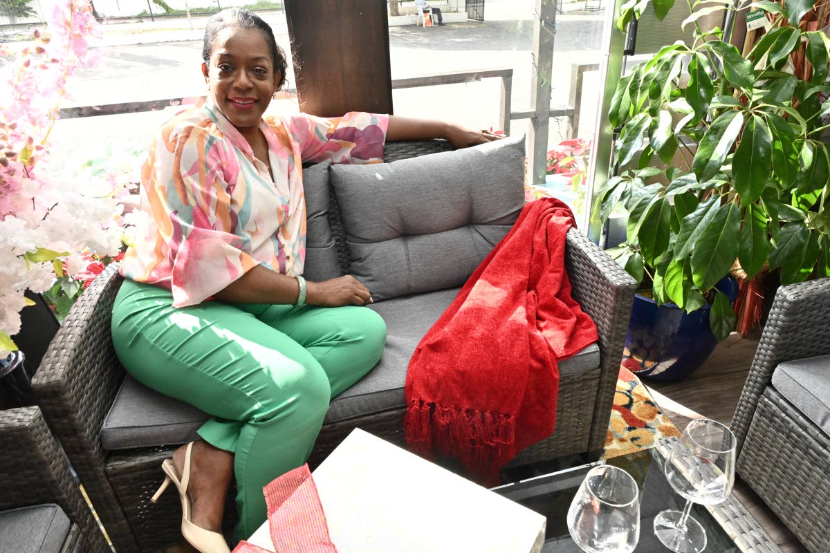 Photos by Rudolph Brown/Photographer 
Suzette Dawkins poses beside a festive red throw, styled on a loveseat, one of the simple décor updates she recommends for adding warmth and colour to a space at Christmas.