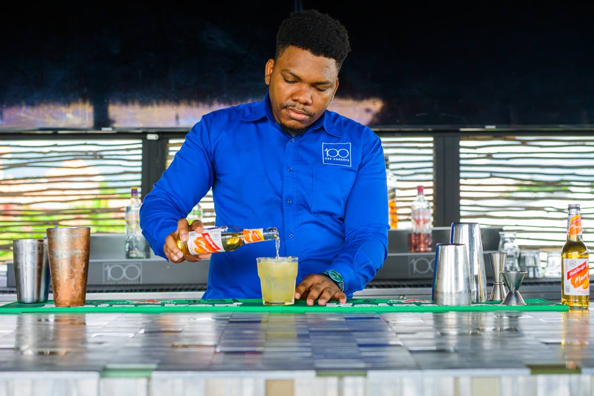 Mixologist Theo Miller pours Red Stripe Mango beer to add the finishing touch to the drink.