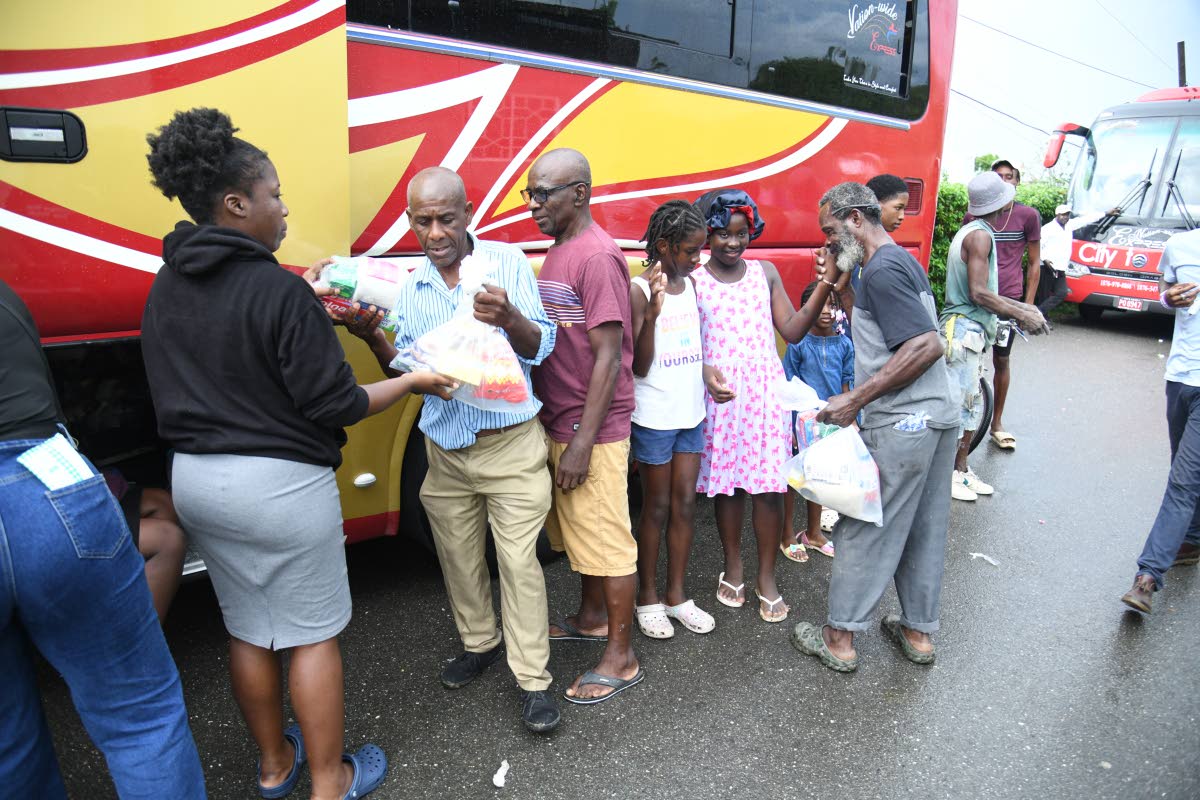 Abigail Sadler (left) distributes care packages to residents of Shrewsbury on December 13 at the Mother Lewis AME Church in Shrewsbury, Westmoreland. 