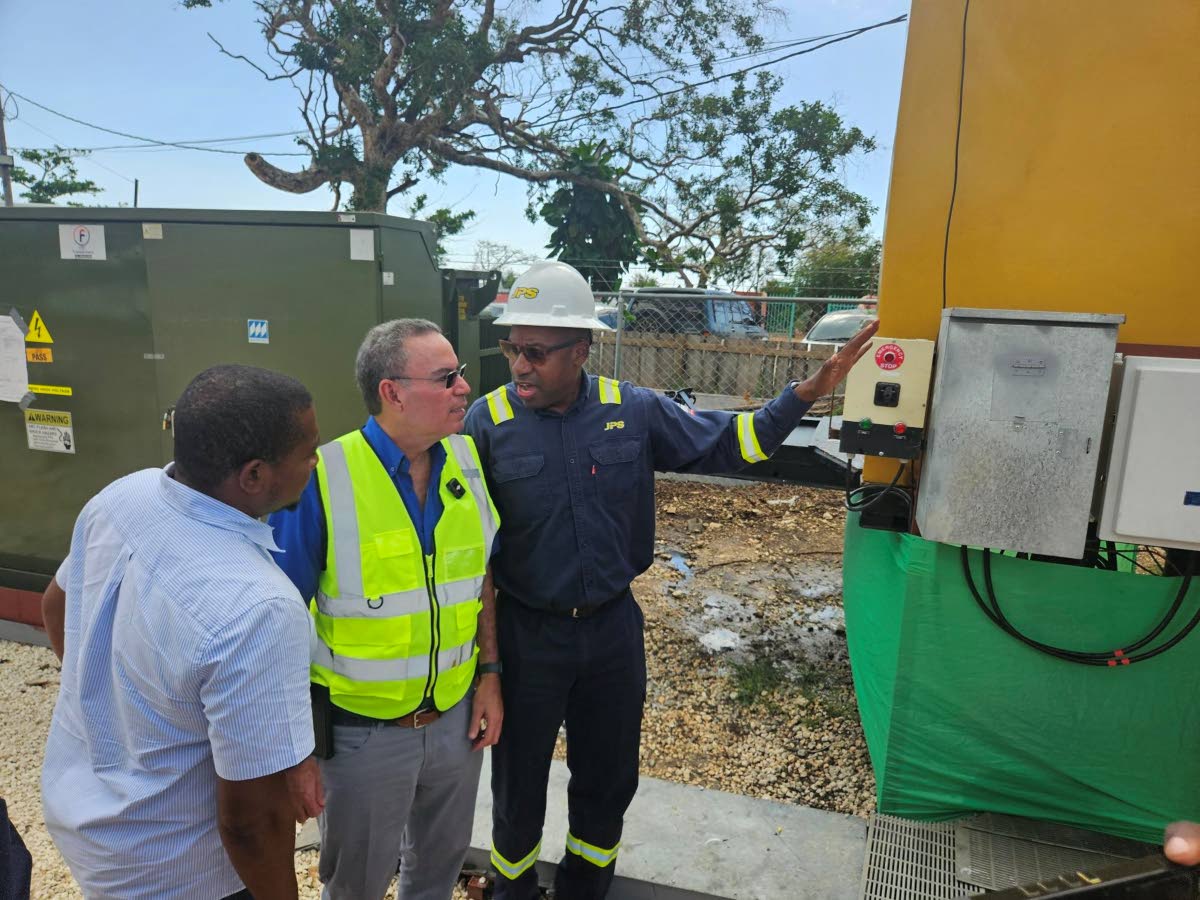 JPS CEO Hugh Grant (right) explains the operation of the new JPS Emergency Mobile Power Generation Unit to Energy Minister Daryl Vaz (centre) and Member of Parliament for St Elizabeth South Western Floyd Green.  