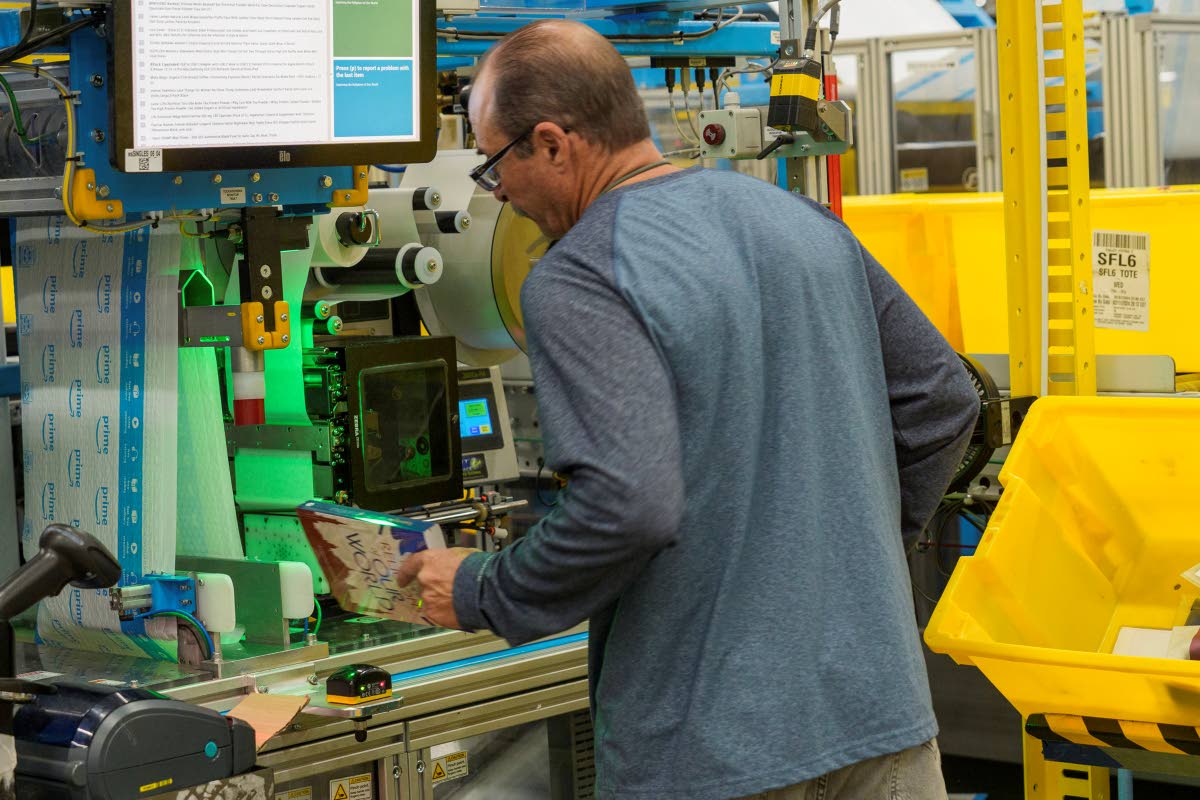 AP Photos
An employee uses an automated packaging machine to create a made-to-measure bag for a book at Amazon OXR1 fulfilment centre in Oxnard, California, USA in 2024. 