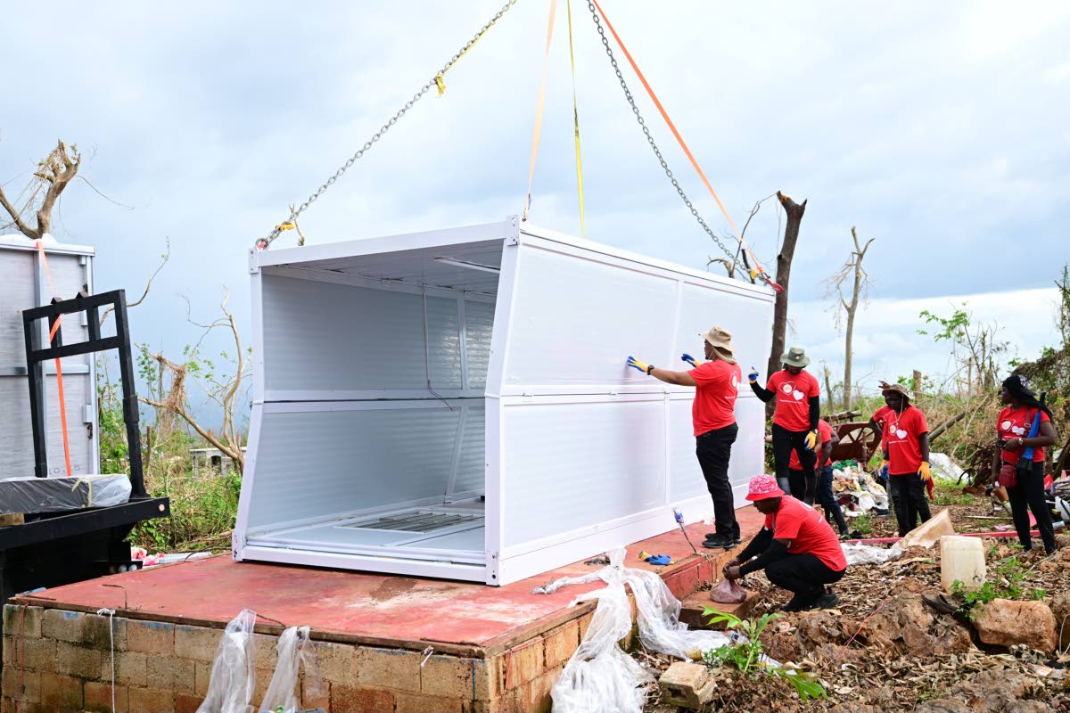 Volunteers install a container house for mother of six, Ashella Baker, in Middle Quarters, St Elizabeth.