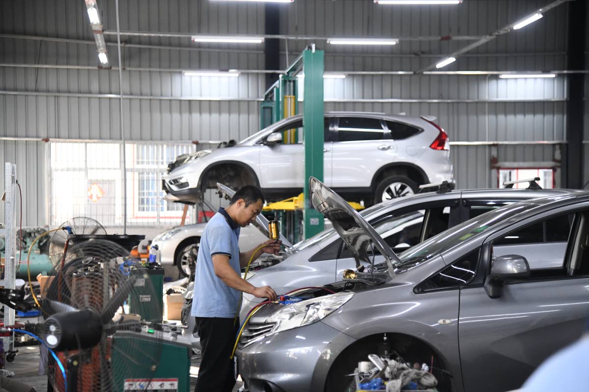 Jong Zhangcanqiang carries out work on a vehicle at the WH Car Service station at Ferry in St Catherine on April 22, 2025. 