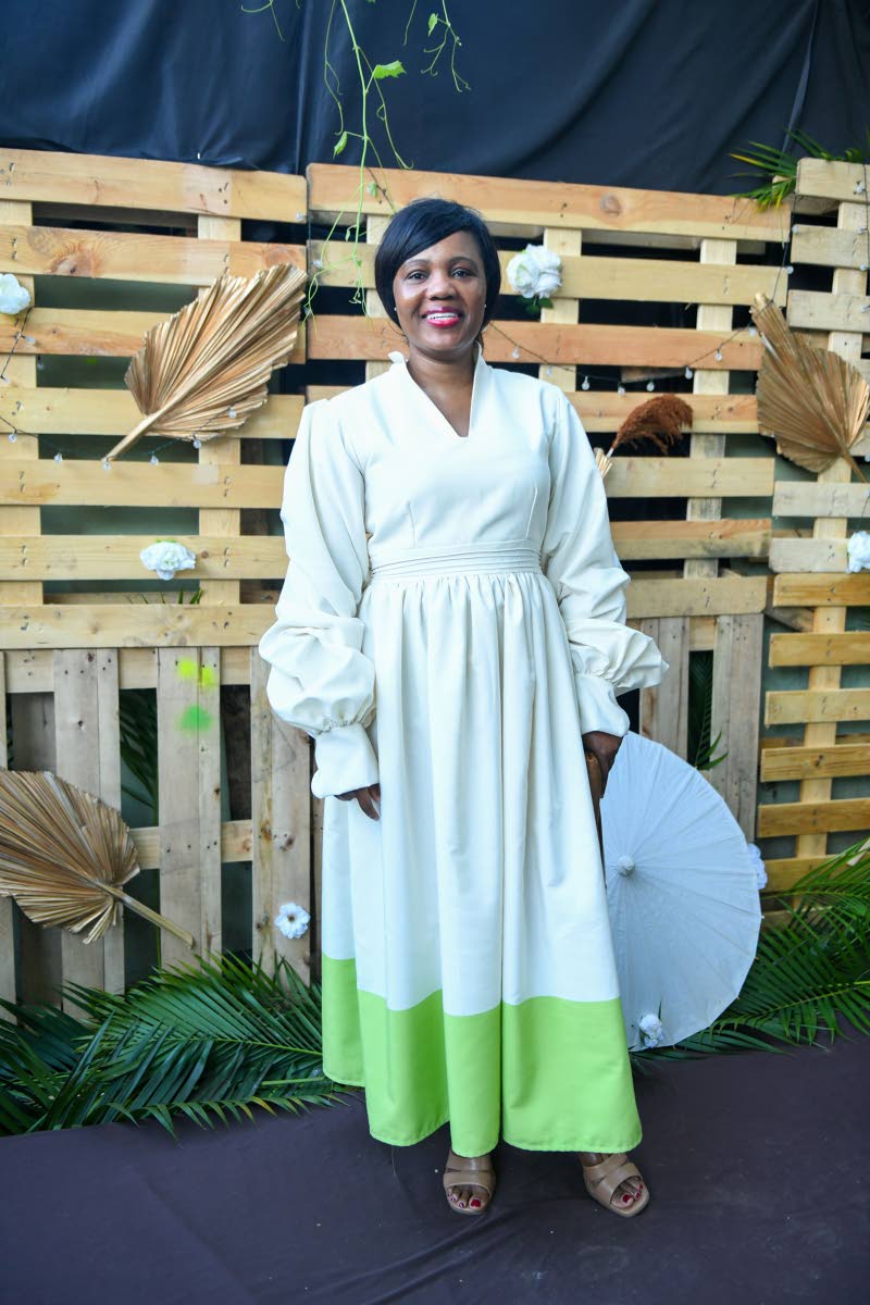 In a touch of green, Kadine Reynolds exudes poise and grace in a luxe maxi two-tone dress from none other than Lucien Harrison.