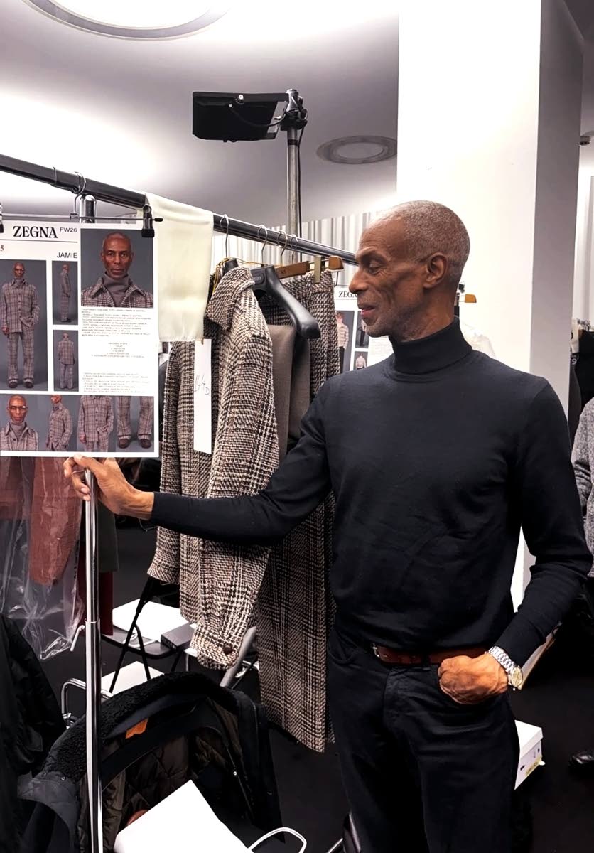 Melbourne looks at his garment tag during his Zegna runway appearance.