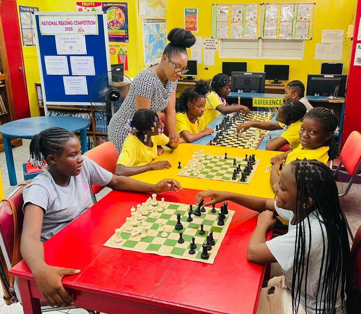 Girls Becoming mentees challenge each other in a lively game of chess. 