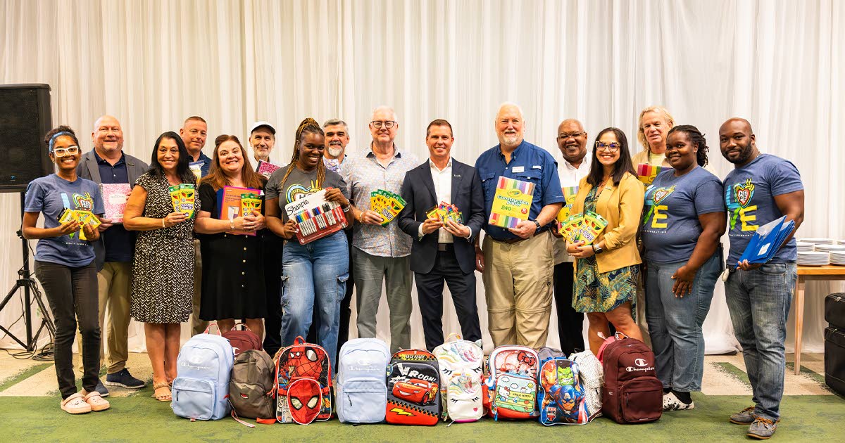 Adam Stewart, executive chairman for Sandals Resorts International (centre) and Sandals Foundation volunteers from the Montego Bay Region receive packages of school supplies from Ttavel agents at the Travel Leaders Network Conference at Iberostar in early 