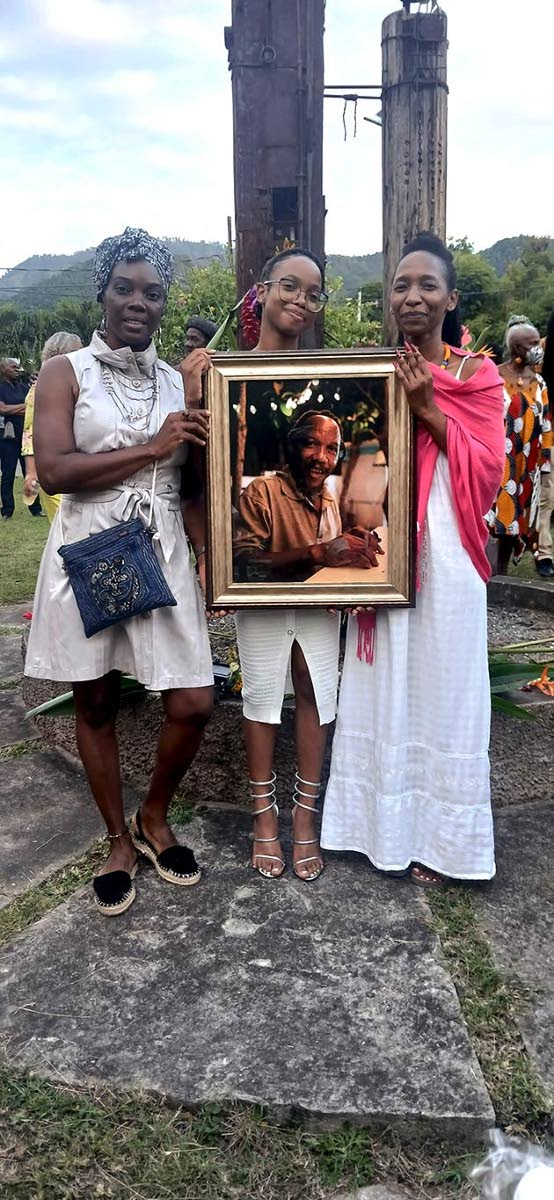 From left: Artisan Marcia Adam, Maguwa Wamazola and Meloddi Mazola holding a framed photograph of Mazola wa Mwashighadi at the celebration of the artist’s life on January 17.