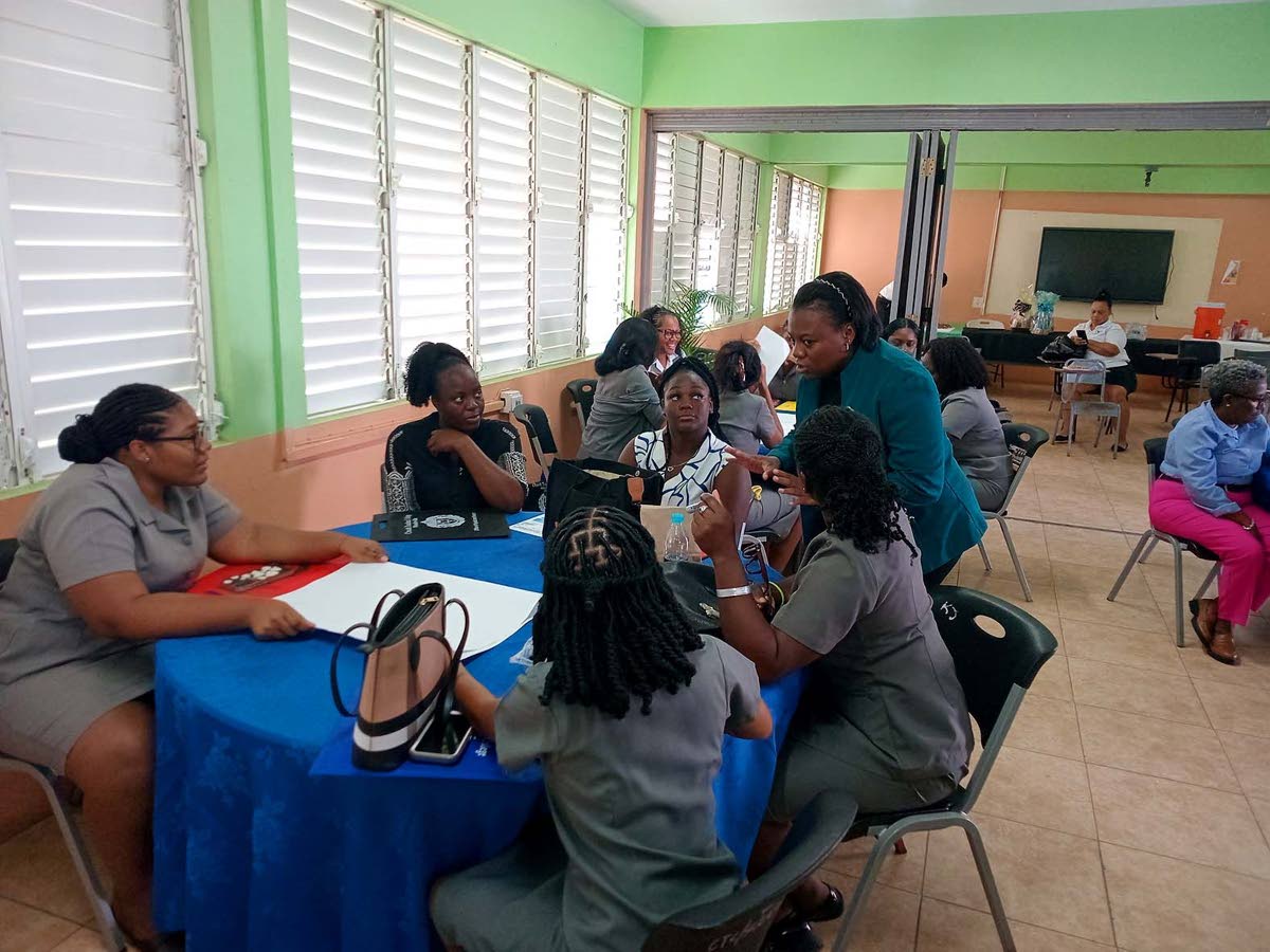  Pitta-Gaye Powell (right), of the NPSC, provides guidance to participants on preparing their objectives. 