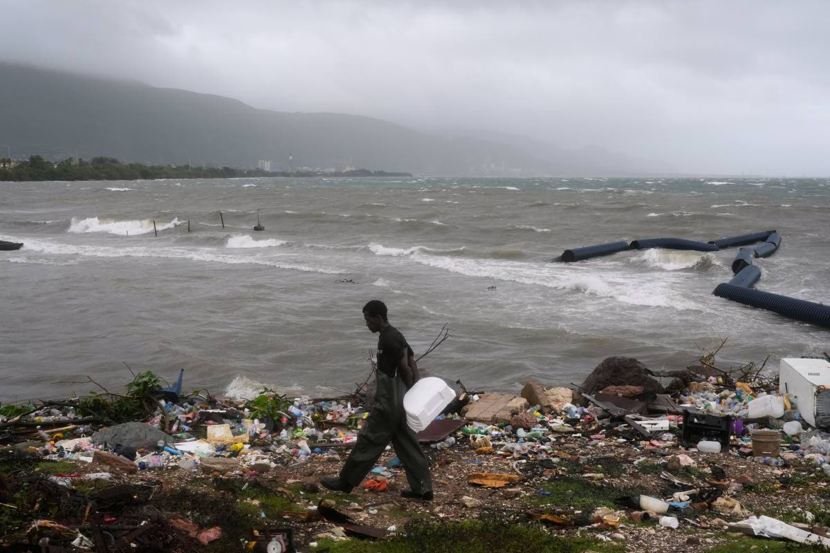 A man walks along the coastline during the passing of Hurricane Melissa in Kingston.