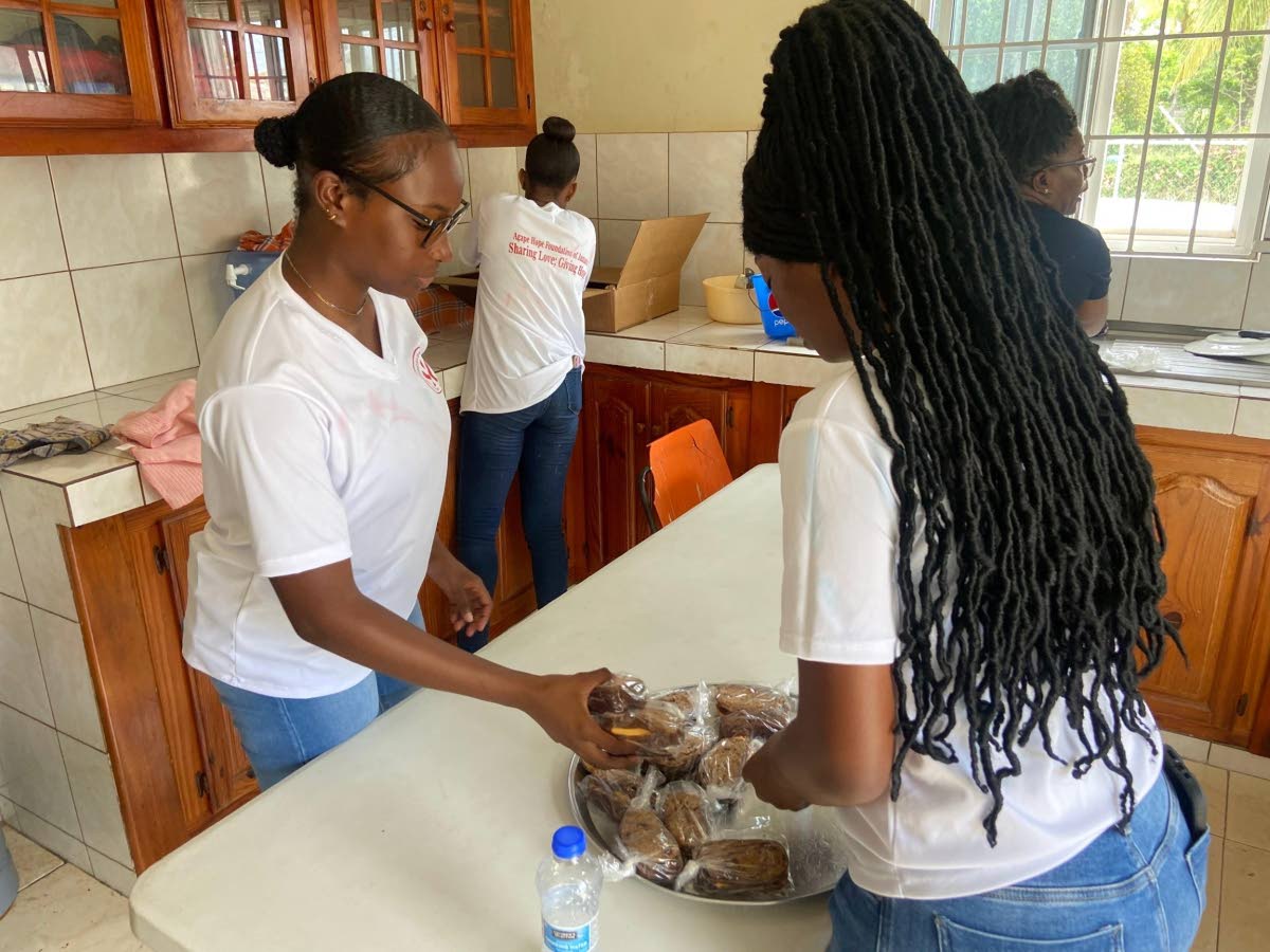 Agape member Adrienne Parry (left) leads the preparation of food for distribution.