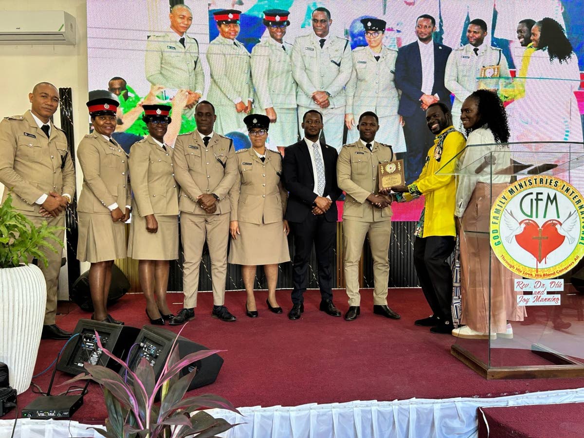 The Reverend Dr Otis Manning presents the St Andrew North Management team with a plaque. 