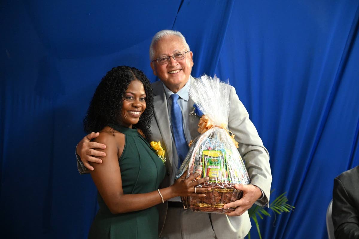 Minister of Justice Delroy Chuck accepts a gift from a newly commissioned Justice of the Peace, Noelle  StacyAnn Randall, following his keynote address at the JP commissioning ceremony at The Commingle Hotel in Westmoreland.