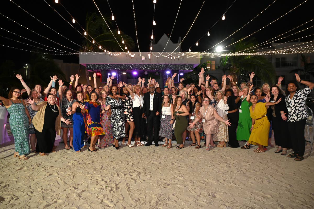 Tourism Minister Edmund Bartlett (centre) poses with several travel agents for a group shot during a special welcome dinner for Apple Leisure Group (ALG) at RIU Montego Bay on January 31. 