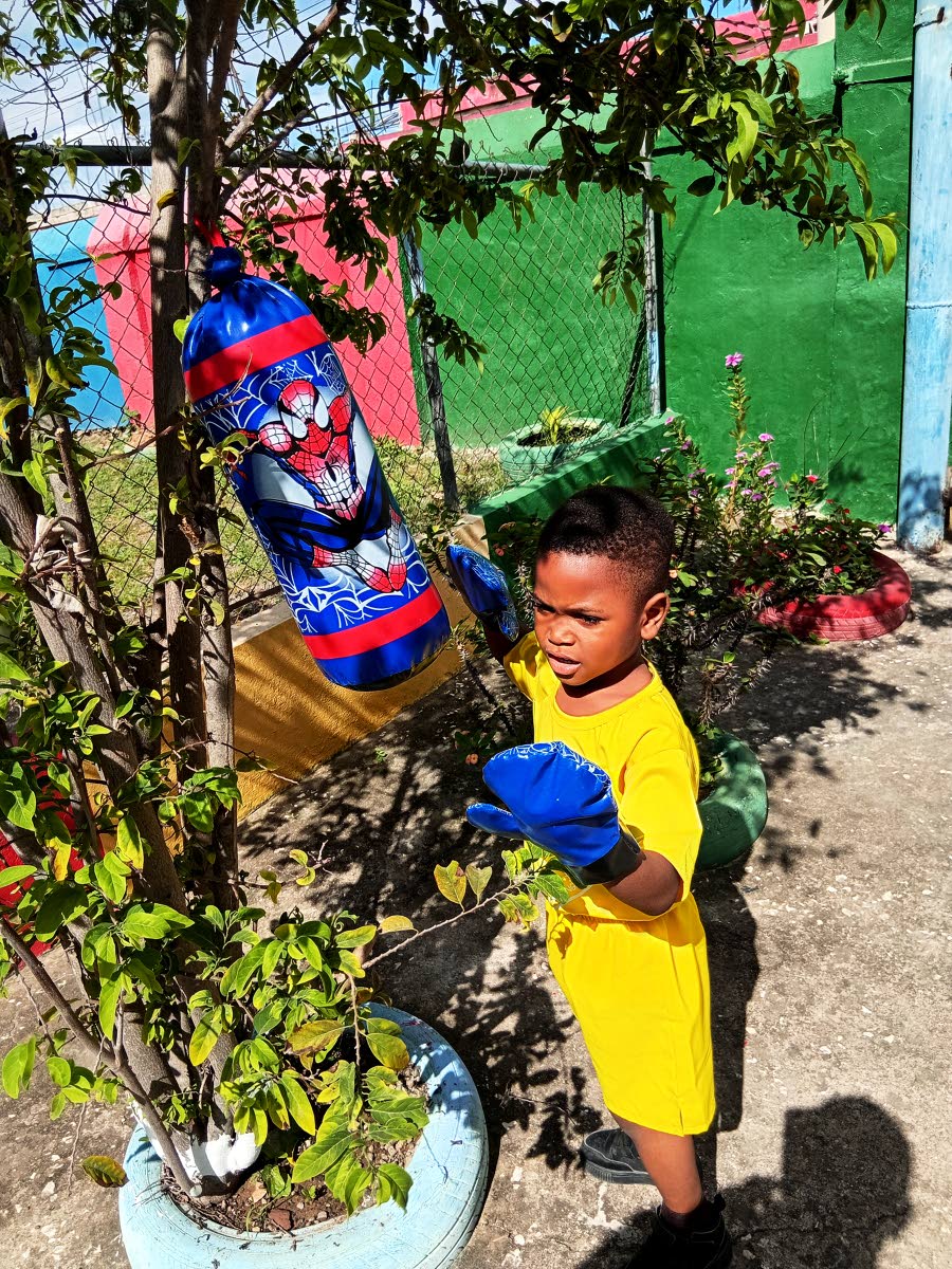 A young boy takes part in a fun boxing session during Play Day activities at Kingdom Builders Early Childhood Development Centre.

