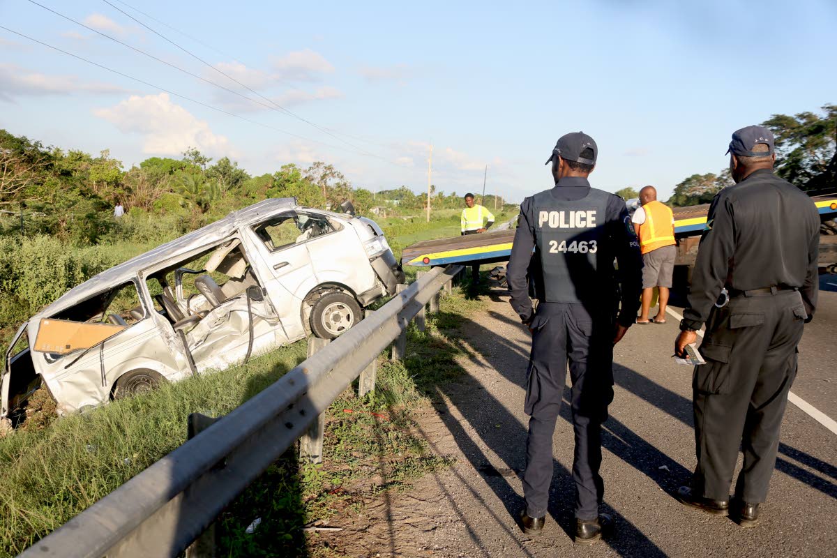 
In this October 2025 photo police officers are seen at a scene of an accident, as a wrecker removes the Toyota Hiace minibus that crashed along West-East leg of Highway 2000, close to the Vineyard Toll Plaza. 