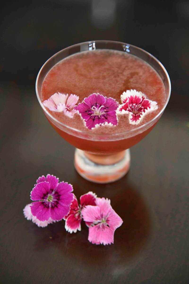 Left: Garnished with edible flowers, Hudson’s raspberry martini includes Wait A Bit Yellow Yam Vodka, distilled in Trelawny. 