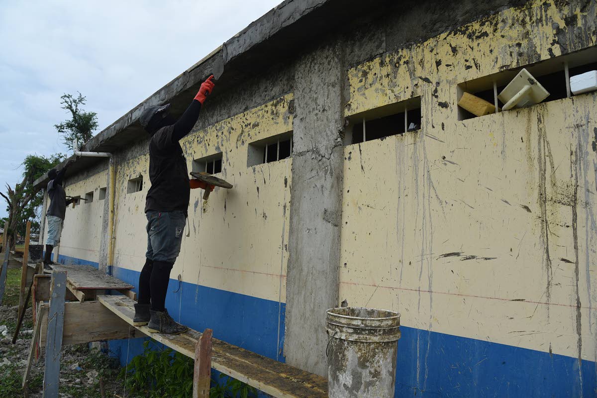Construction workers repairing a section of the roof at Lacovia Primary School on February 5.