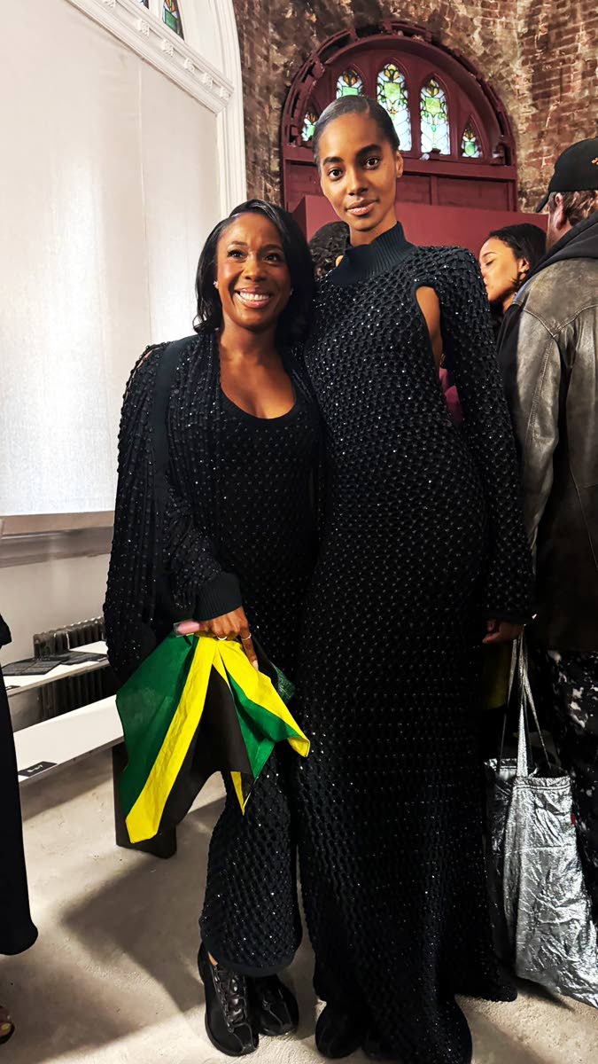 Jamaican flag in hand and styled in a Diotima ensemble, sprint legend Shelly Ann Fraser-Pryce (left) poses with fellow ‘yardie’ and model Tami Williams, post-show.