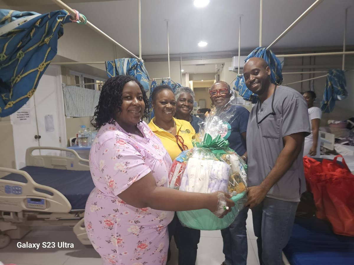 Smiles all around as the Rotary Club of Savanna-la-Mar presents a gift package to Natasha McKenzie Petgrave on New Year’s Day.