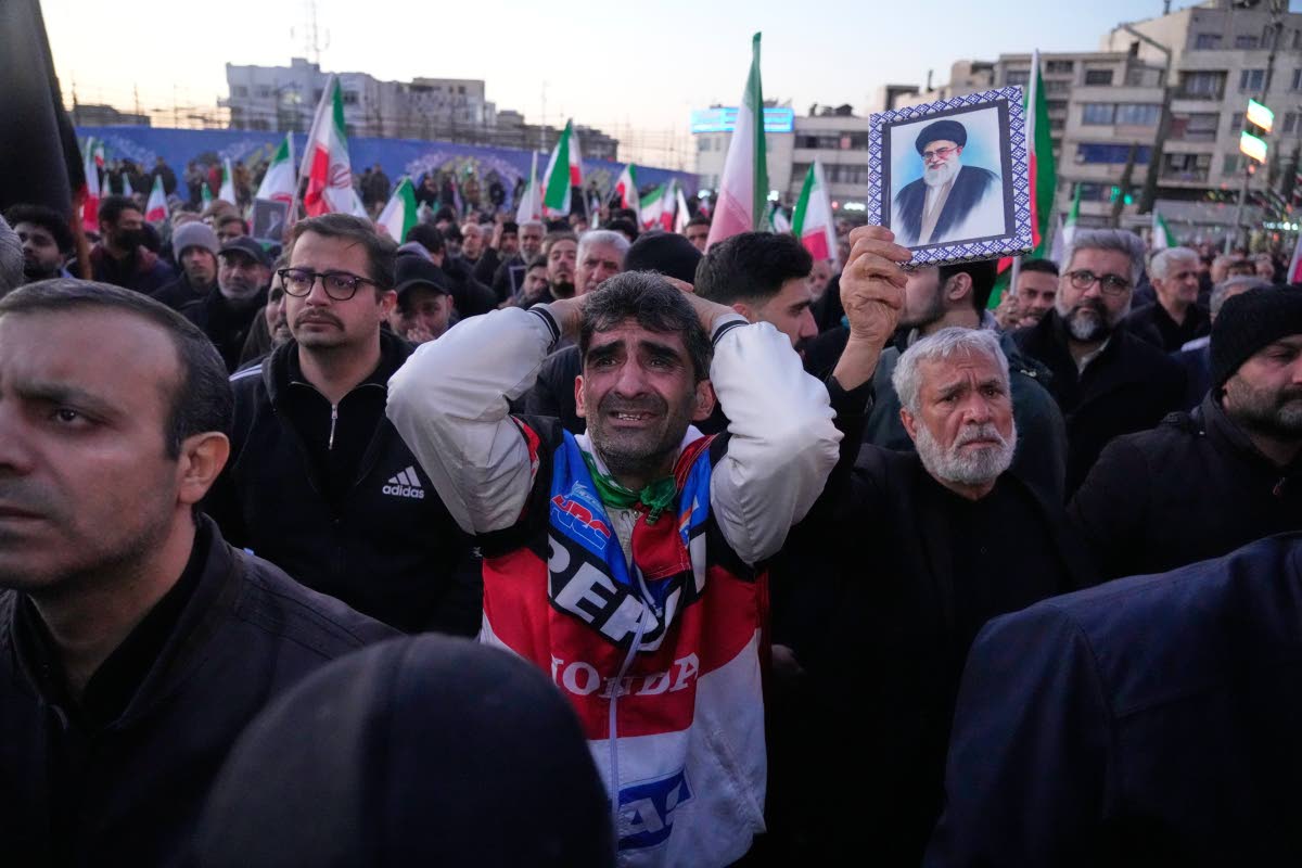 Government supporters mourn during a gathering after state TV officially announced the death of Iranian Supreme Leader Ayatollah Ali Khamenei, shown in the poster, in Tehran.