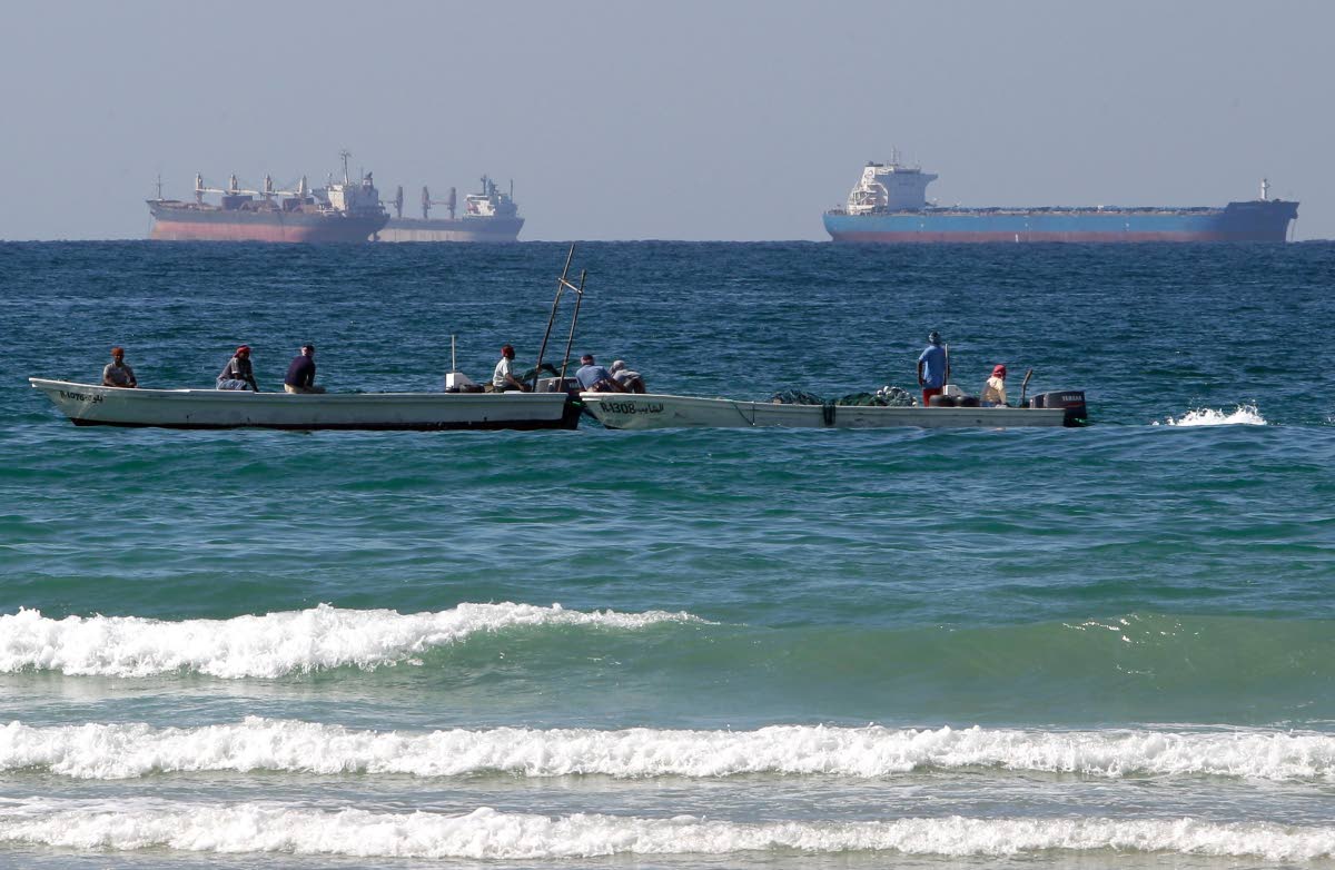 Fishermen work in front of oil tankers south of the Strait of Hormuz January 19, 2012, offshore the town of Ras Al Khaimah in United Arab Emirates. (AP Photo/Kamran Jebreili, File)