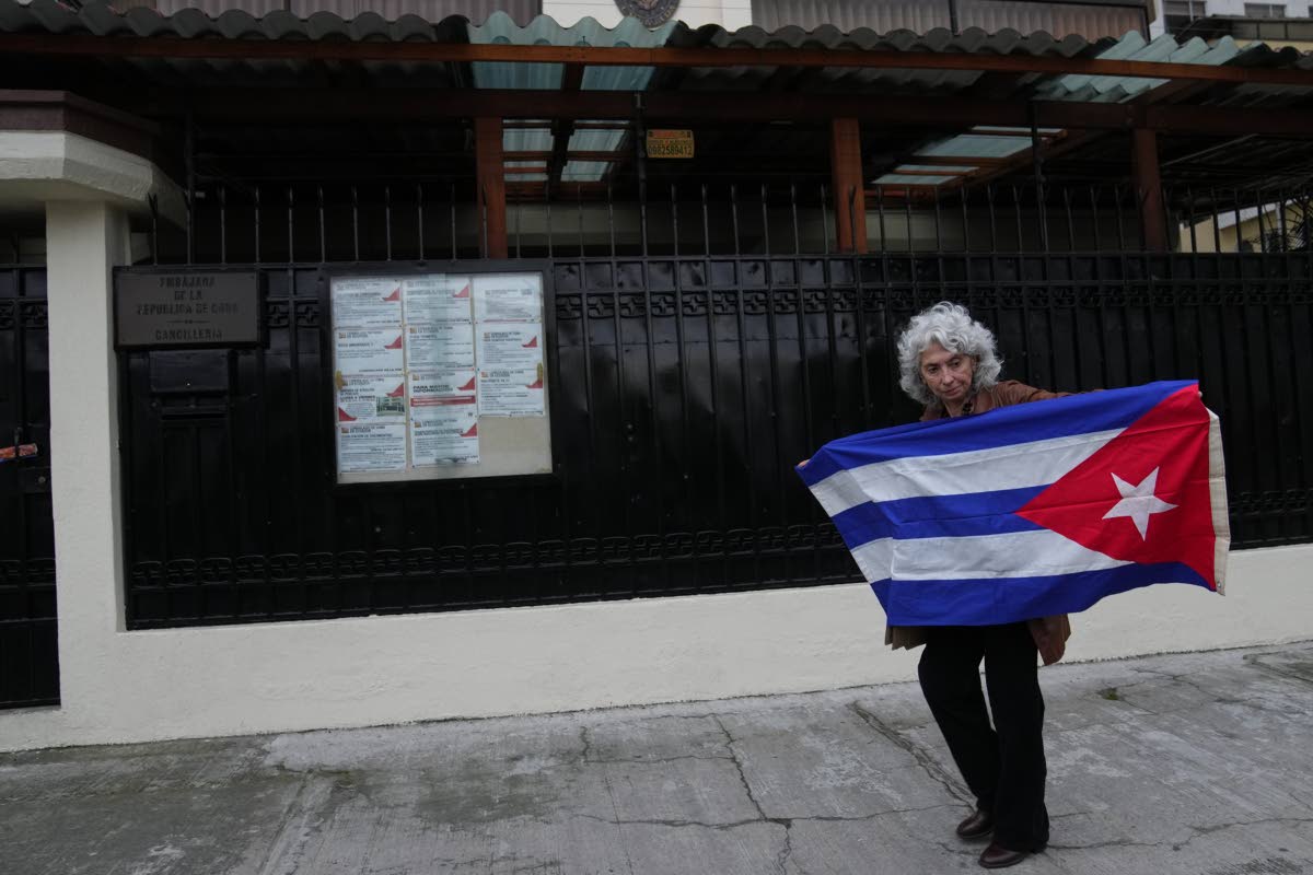 A woman holds up a Cuban flag outside the Cuban Embassy in Quito, Ecuador on March 4, 2026. (AP Photo/Dolores Ochoa)