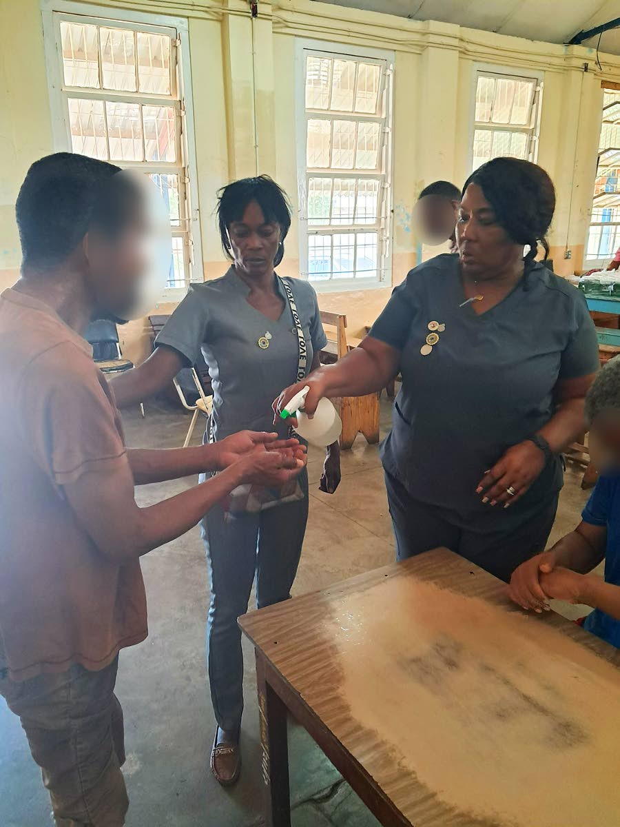 Psychiatric nursing aides Lorraine Grant and Hulian Gentles sanitise patients before lunch.