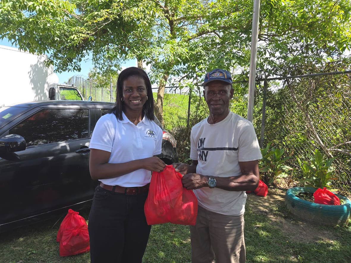 Jonelle Llewellyn, research associate at the Violence Prevention Alliance, presents a care package to a resident of Chalky Hill in St Ann, recently.