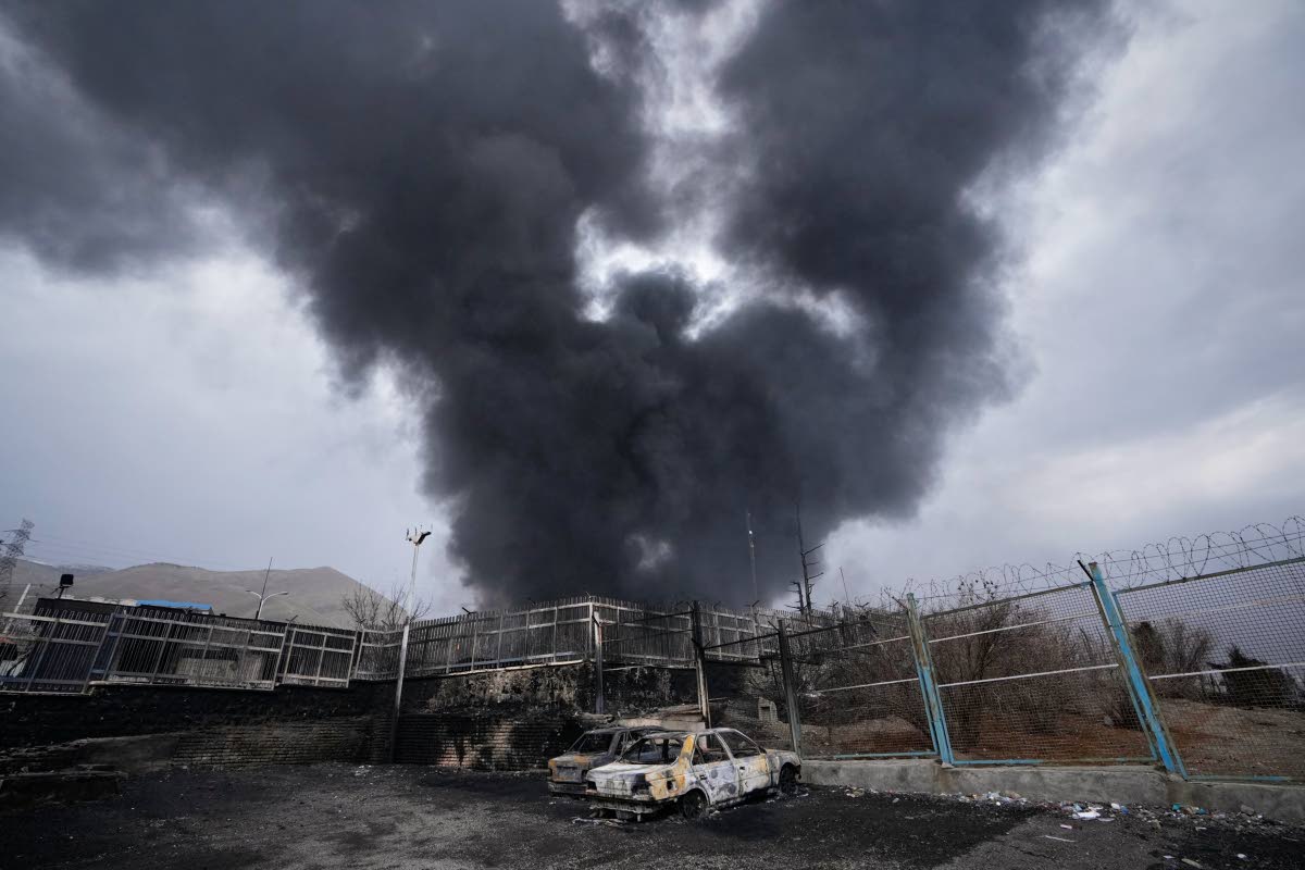A thick plume of smoke rises from an oil storage facility hit by a US-Israeli strike in Tehran, Iran on March 8, 2026. (AP Photo/Vahid Salemi)