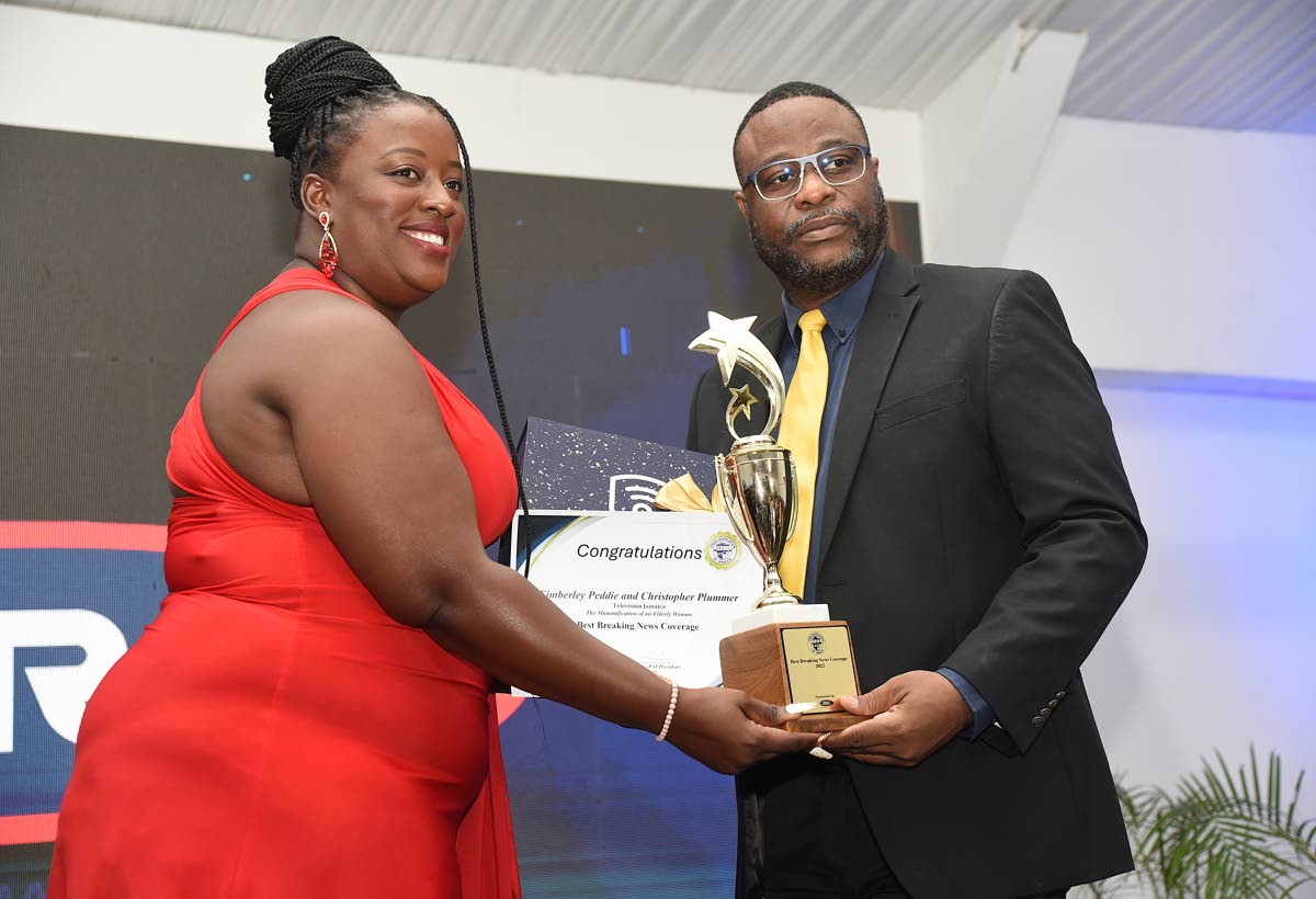 Kimberley Peddie (left) of Television Jamaica accepts the award for Best Breaking News Coverage from Press Association of Jamaica President Dashan Hendricks. She shares the award with Christopher Plummer.