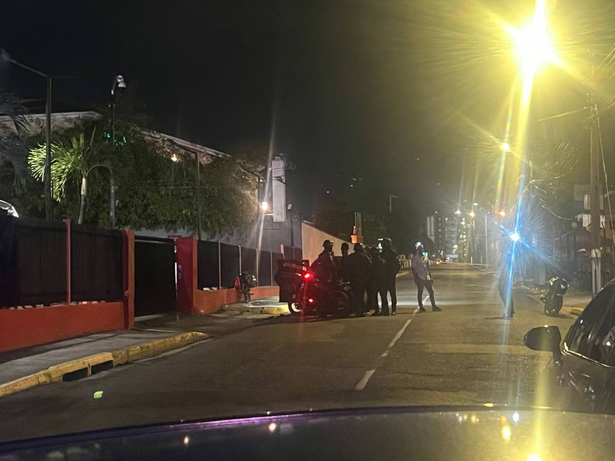 Investigators surround a Honda Fit motor car following a fatal shooting on Ruthven Road in St Andrew on March 12, 2026. 