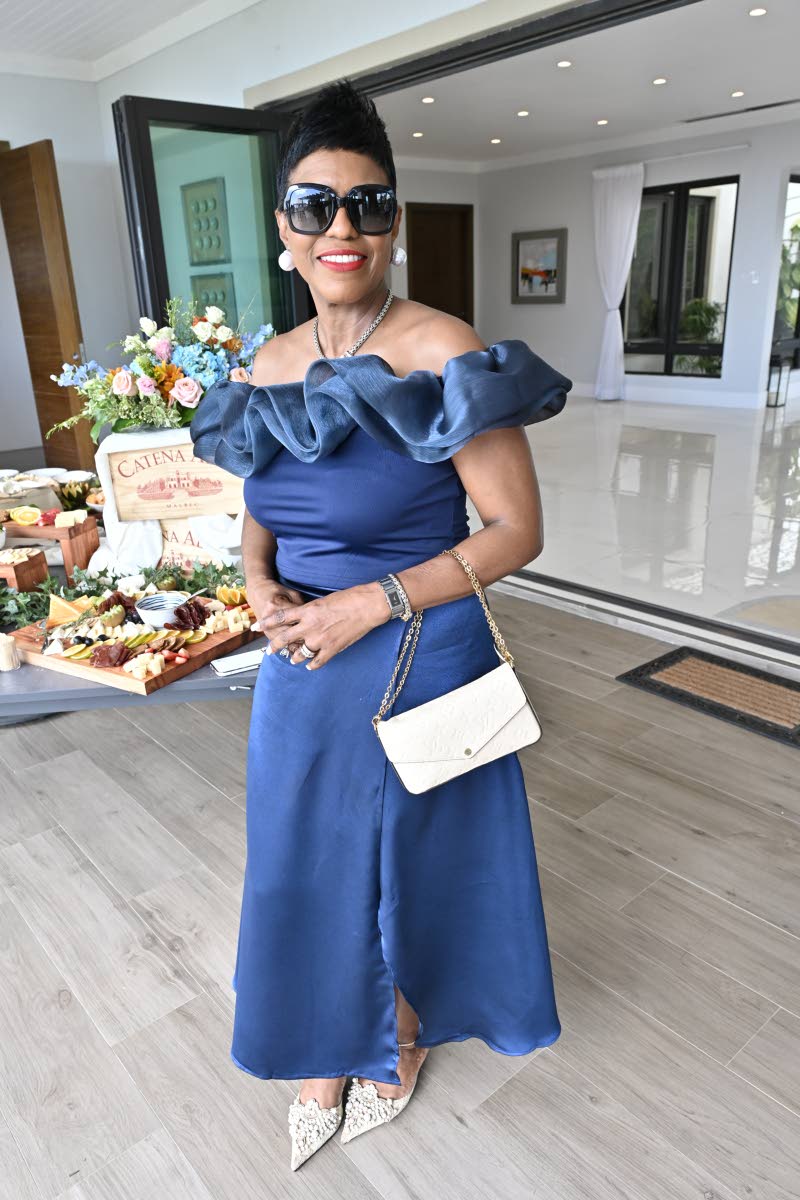 Audrey McIntosh, head of private banking at National Commercial Bank, rocks a blue off-the-shoulder midi dress, perfectly paired with white accessories. 