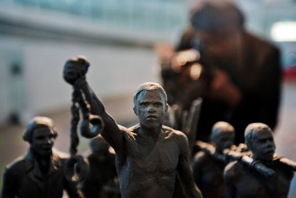 FILE - A man photographs a maquette of a statue, at City Hall, London, Monday, Aug. 18, 2008. 
