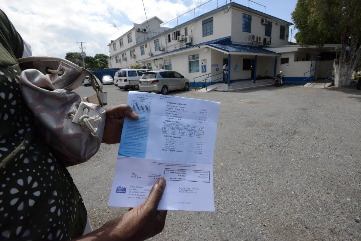 
A lady checks her water bill before making payment at the National Water Commissioner office on Marescaux Road, Cross Roads, in 2016.