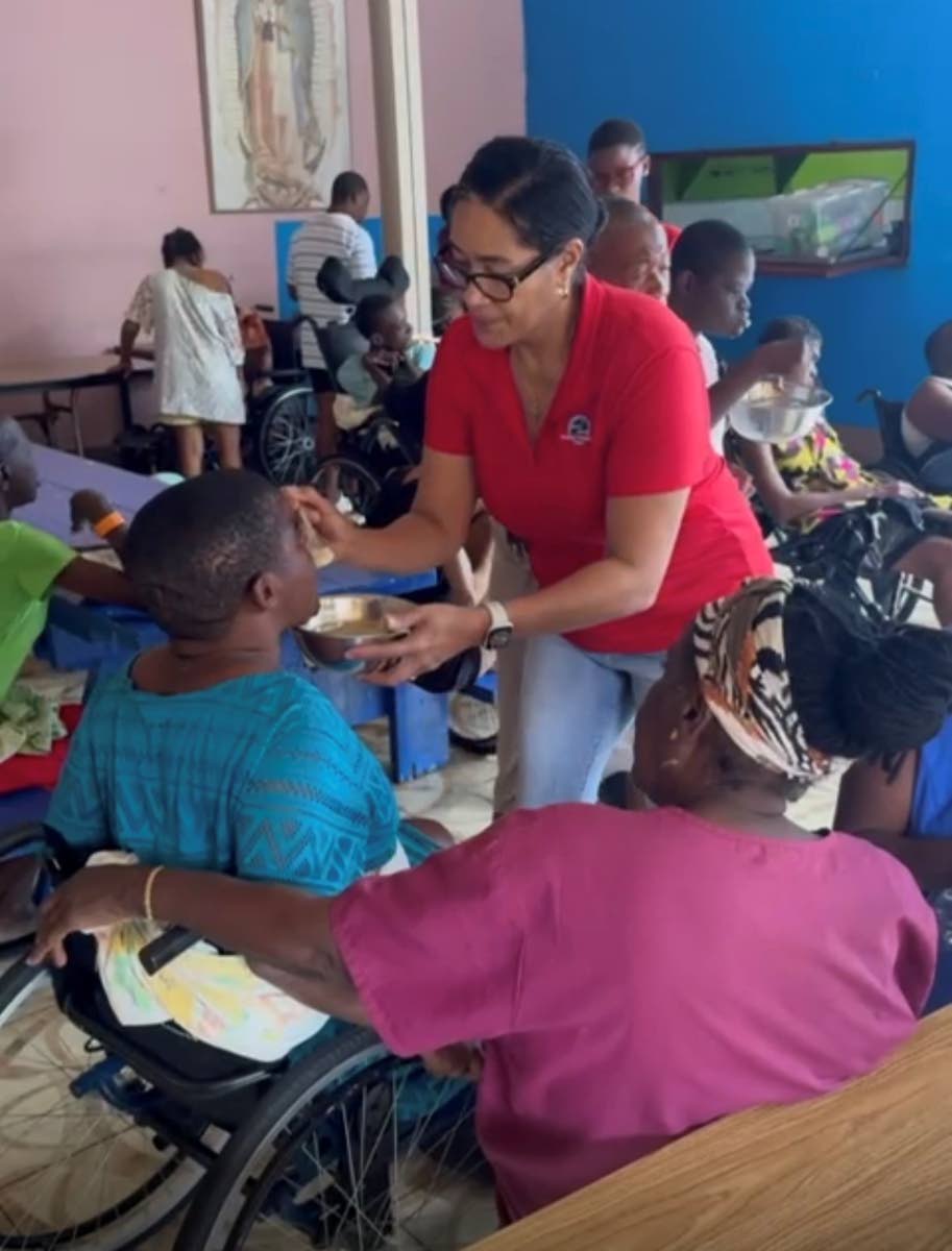 Rachel Matthews, Shipco Transport’s regional manager for the Caribbean, feeds one of the residents while at the Jacob’s Well residential care facility for women.