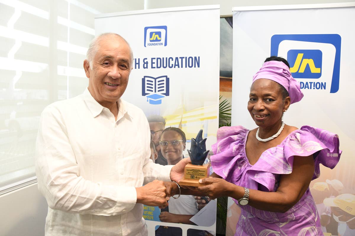 Parris Lyew-Ayee, chairman of the JN Foundation, presents Marjorie Gaynor, former director, D.R.B. Grant Early Childhood Resource Centre, her award.