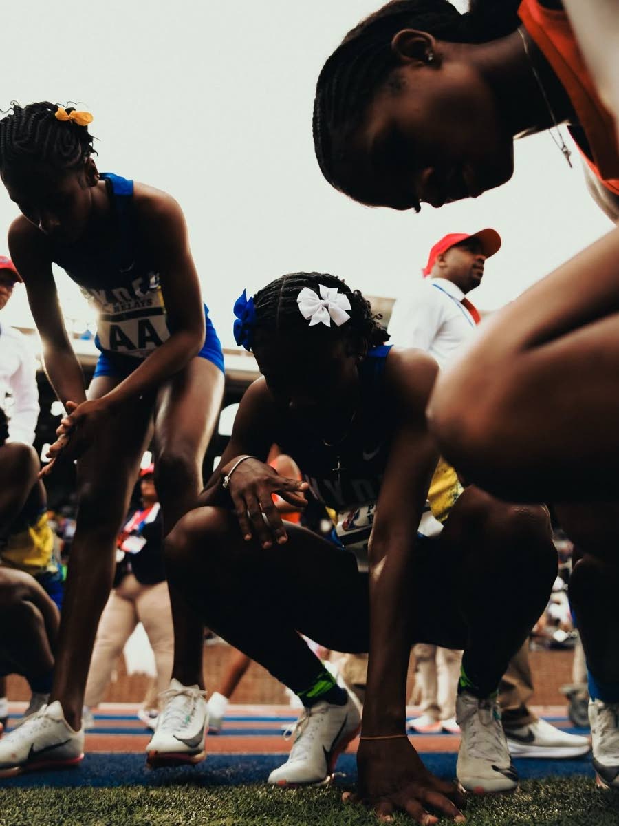Hydel High School's girls catch a breath after winning a record fifth-straight Championship of America 4x400m relay title.