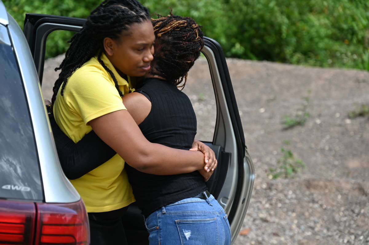 Akeem Williams, mother of 10-year-old Shani Coke who was raped and murdered in her community of Tire, Troy in Trelawny, seen hugging a relative.