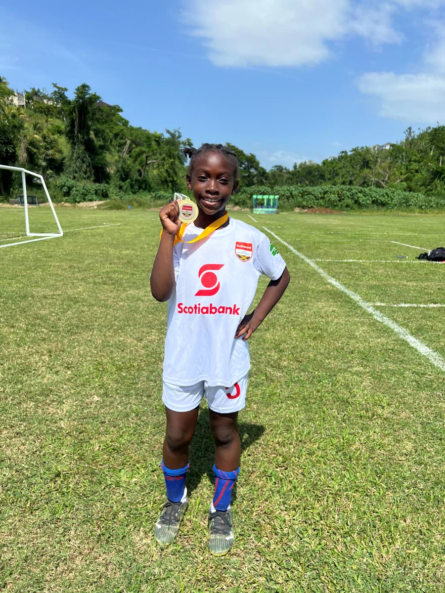 10-year-old Ricshi Scarlett proudly displays her first-place medal at the Scotia Kids Football Championships finals on May 31. The Rousseau Primary student discovered a passion for football after taking up the sport less than a year ago.