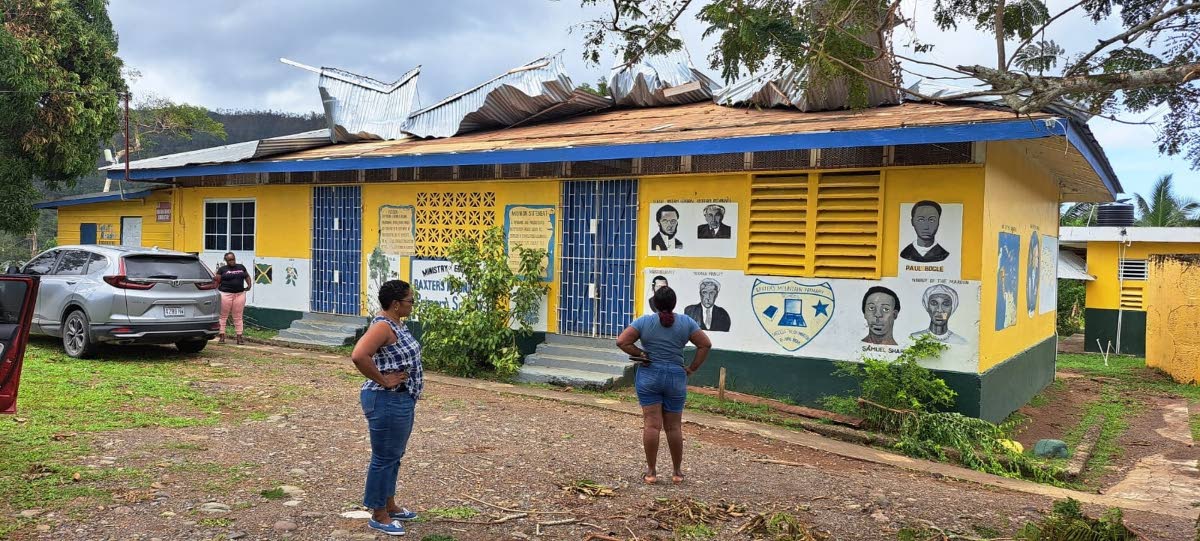 Teachers examine the damage to the roof at Baxter’s Mountain Primary in St Mary.