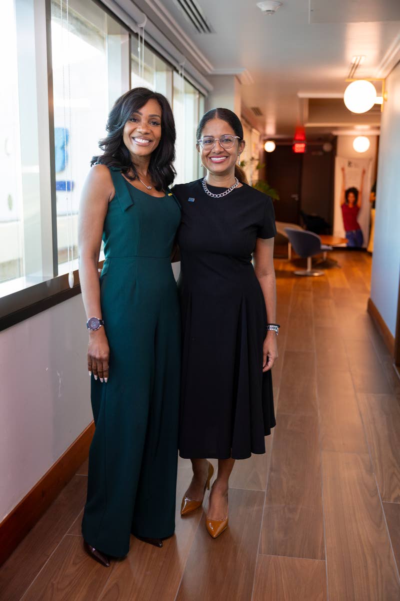 Right: Wearing a forest-green sleeveless jumpsuit, Belinda Williams (left), head of group corporate affairs at NCBJ, poses alongside Sheree Martin, interim chief executive officer of NCBJ, who is dressed in a classic black short-sleeve midi dress.