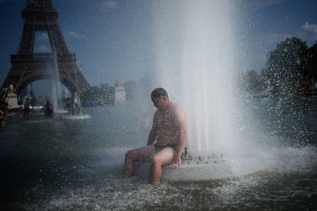 A person cools off at Trocadero fountain near the Eiffel Tower during a heat wave in Paris, on June 24, 2026. 