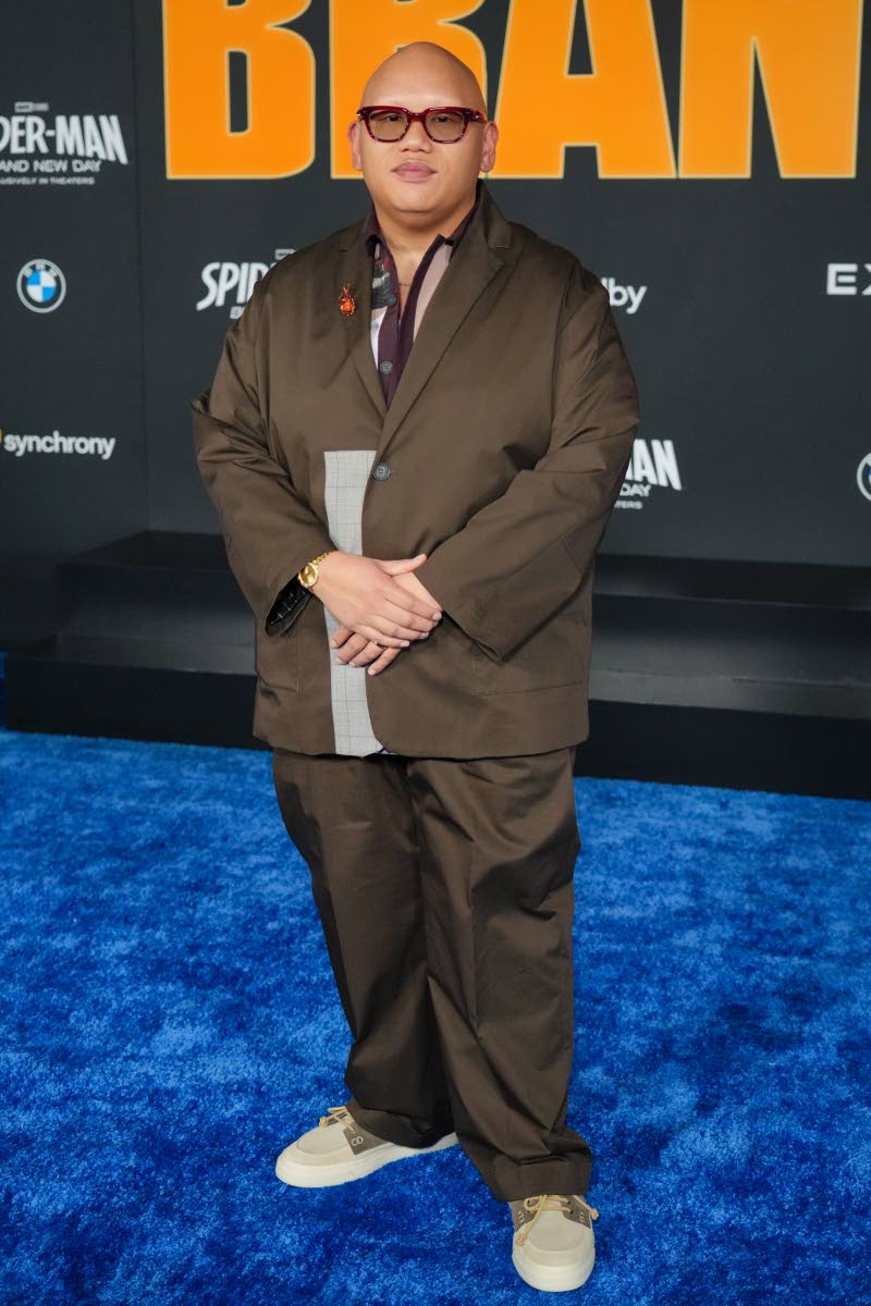 Jacob Batalon wears an oversized espresso-brown single-breasted suit, styled with Ronnie Fieg x Clarks 8th Street Sunderland shoes in the khaki and olive colourway, featuring a multi-panel suede construction.