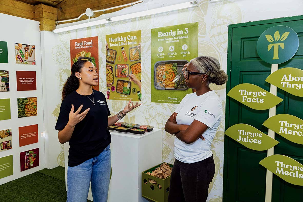 Gayon Douglas (right), executive director of the C.B Facey Foundation, listens intently as final-year graphic design student at the Edna Manley College of the Visual and Performing Arts, Kimberley Jones, passionately shares the rationale behind Thryve Food