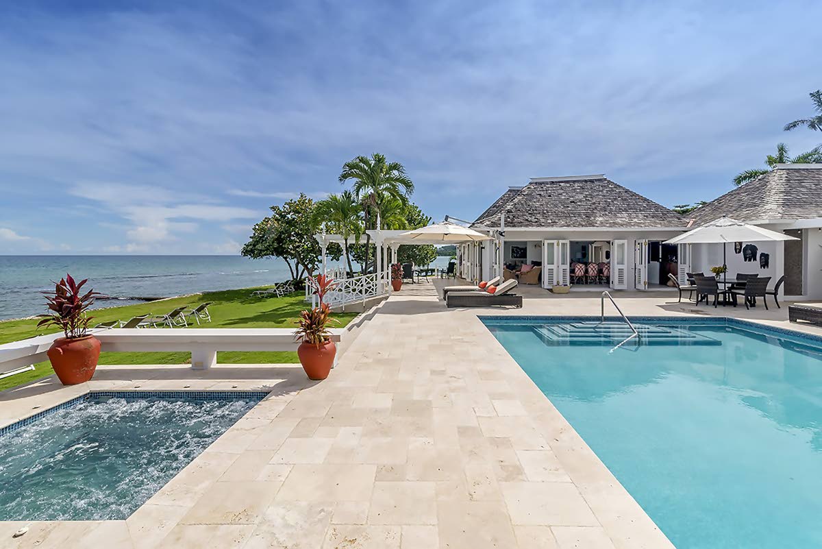 An aquatic playground of a beach, hot tub, and pool unite in one place. 